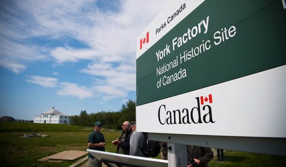 Panneau d'orientation au lieu historique national du Canada York Factory, guidant les visiteurs à travers les sentiers et les lieux historiques.