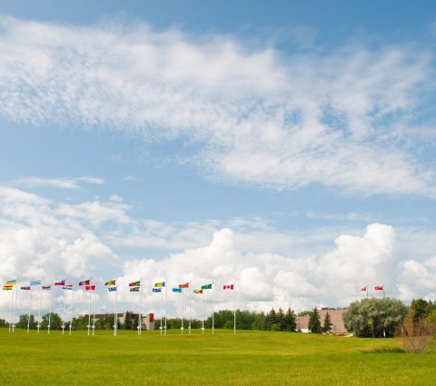 Monnaie royale canadienne avec des drapeaux internationaux devant le bâtiment