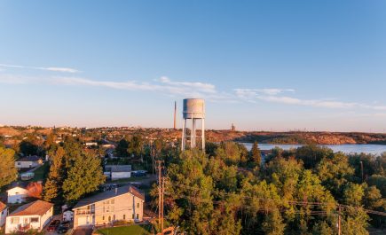 Photo prise par un drone surplombant la ville de Flin Flon, dans le nord du pays, avec un château d'eau au loin.