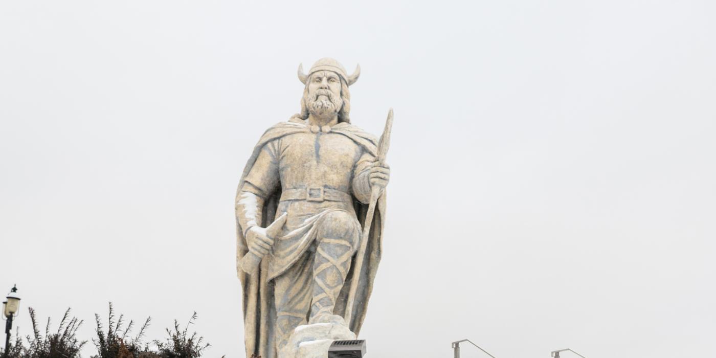 La statue du viking de Gimli recouverte de neige, par une journée nuageuse.
