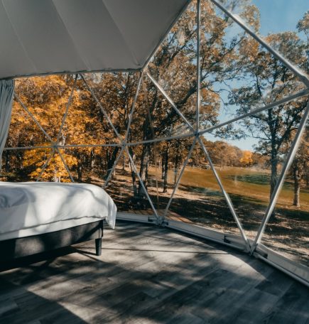Vue de l'intérieur d'une cabine à dôme géodésique chez Moonlit Canopies à travers les vastes fenêtres.