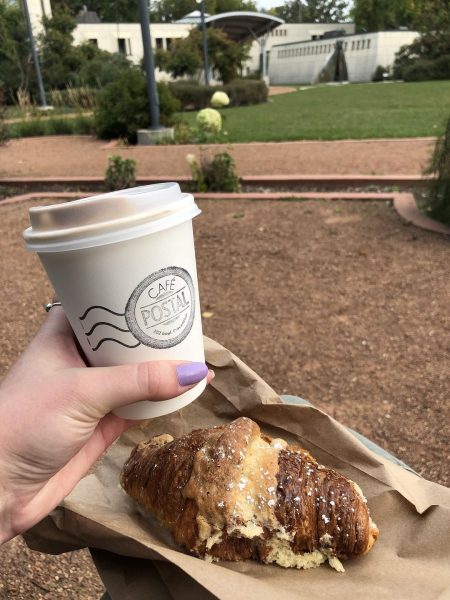 Quelqu'un brandit un café et un croissant du Café Postale à Saint-Boniface.