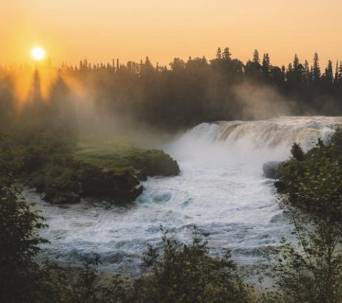 Coucher de soleil à travers la brume montante aux chutes de Pisew.