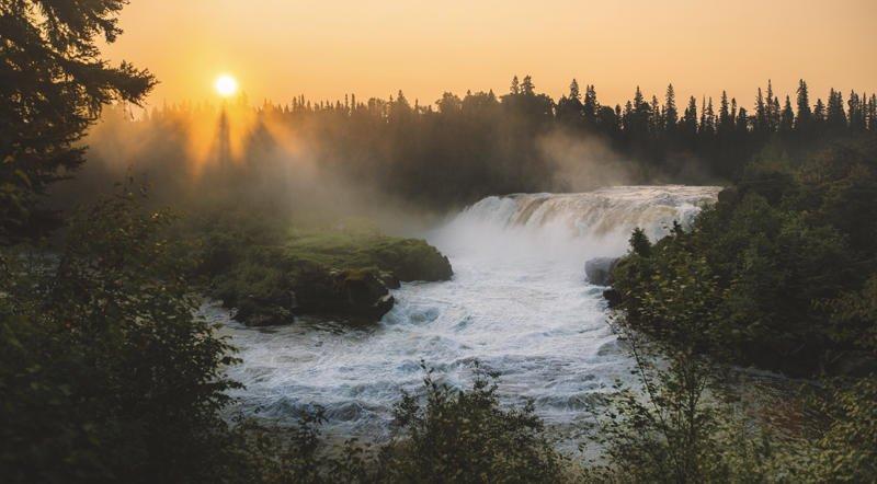 Coucher de soleil à travers la brume montante aux chutes de Pisew.